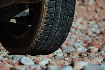 Canvas Print - Car wheel on stones close-up view