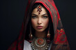 Portrait of a beautiful young brunette woman in red Indian costume on black background