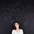 © Helder Almeida - Woman stands beside a chalkboard adorned with hand-drawn hearts