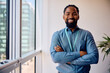 © Drazen - Happy black businessman with arms crossed in office looking at camera.