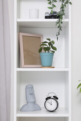 Wall Mural - White bookshelf with houseplant, alarm clock and decor