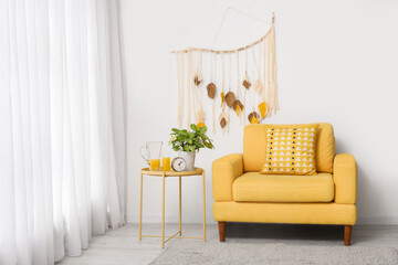Wall Mural - Interior of living room with yellow armchair, macrame and alarm clock on coffee table