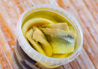 Sticker - Preserved herring fillet in round plastic container served for consumption on the laid table