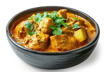 Top Down View Of Spicy Homemade Chicken Curry With Potato And Coconut Milk In A Black Bowl On White Background