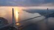 Aerial view of Istanbul's 3rd cable bridge YSS at sunset. The sun rays reflect on the water under the dense cloud layer over the Bosphorus
