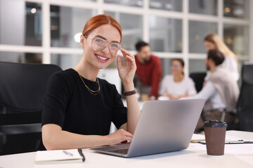 Poster - Team of employees working together in office. Happy woman with laptop at table indoors