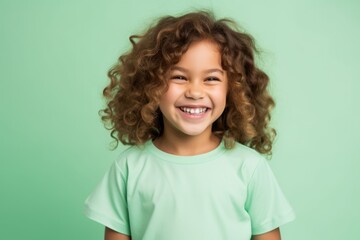 portrait of smiling african american little girl in green t-shirt