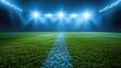 Football stadium view illuminated by blue spotlights and empty green grass field.