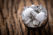 close up shot of single space coil in high end rebuildable dripping atomizer for flavour chaser on rustic natural wood texture background, vaping device