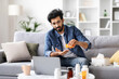 © Prostock-studio - Indian man pouring pills from bottle into hand while sitting on couch
