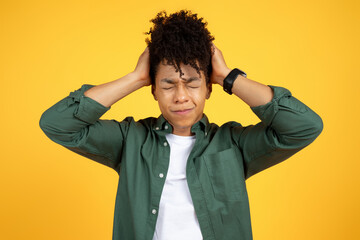 Stressed young african american guy touching his head