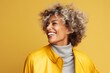 © Inigo - Portrait of young beautiful african american woman with curly hair in yellow jacket on yellow background