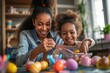Cheerful little girl is painting Easter eggs with her mother An African American family dying Easter eggs and celebrating Easter. 