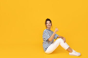 Wall Mural - Attractive young girl posing on a yellow background