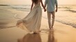 A woman in a silk dress was holding her husband's hand and they were walking along the beach. Cropped image of romantic couple