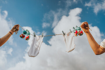 Individuals are seen holding a laundry line with baby garments