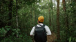 © M Stocker - A man backpacker traveling alone in forest wild. Young man hiking trip through the green forest with backpacks. Asian man traveler explore while walking in green forest. Travel and backpack concept