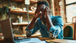 © Studio Nova - Man feeling stressed while working on his laptop. He has his head in hands, a pained expression on face, signifying a headache, frustration, or exhaustion.