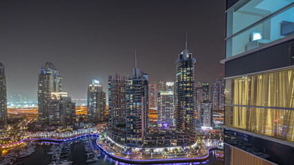 Wall Mural - Panorama showing Dubai marina tallest skyscrapers and yachts in harbor aerial night timelapse.