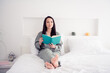 © deagreez - Photo portrait of lovely young lady sit bed read book minded dressed stylish gray sleepwear isolated on white bedroom indoor interior