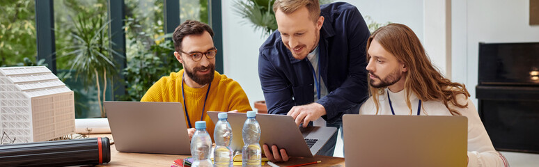 merry attractive businessmen in casual attire working attentively on their startup together, banner