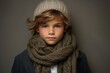 Portrait of a cute little boy in a knitted hat and scarf.