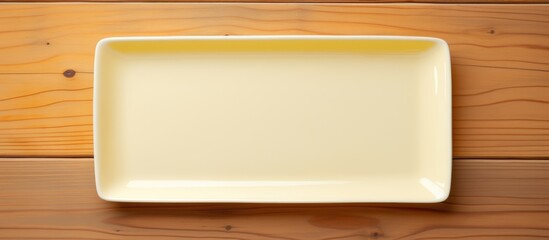 Wall Mural - White rectangle dish on white and yellow wooden table.