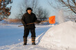 © Parilov - Old Elderly man cleaning snow with shovel after snowstorm.