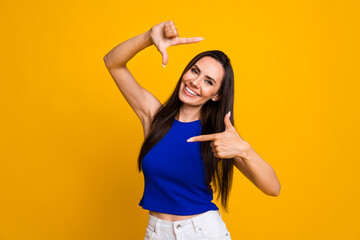 Canvas Print - Photo of cheerful positive lady dressed blue top showing arms photo gesture isolated yellow color background