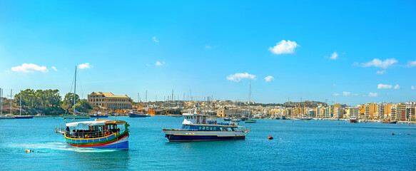 Wall Mural - View of coastline and touristic small ships at harbour. Valletta, Malta