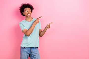 Photo of dreamy sweet man dressed blue t-shirt pointing two fingers looking empty space isolated pink color background