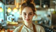 Close up portrait photo of cute young brunette woman with skin imperfection in beige shef clothes in a light cafe kitchen with blurred background