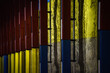 poteaux métalliques rouges, bleus et jaunes, sur un mur en béton brut dans le métro bruxellois