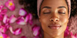 Body skin and hair care. African American young woman in spa salon bathrobe and towel relaxing after taking massage treatment with her eyes closed. Beauty treatment procedures concept