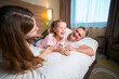 © Viacheslav Yakobchuk - Joyful caucasian family lying and resting on bed in hotel room