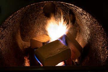 Wood briquettes (ruf type), made of beech and oak burning inside the wood fuel boiler. Alternative fuel, eco fuel, bio fuel.