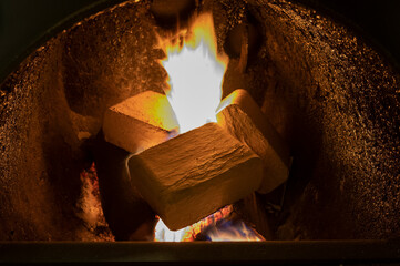 Wood briquettes (ruf type), made of beech and oak burning inside the wood fuel boiler. Alternative fuel, eco fuel, bio fuel.