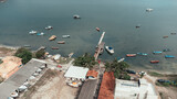 Fototapeta  - Serene Coastal Village: Aerial View of Boats and Sparkling Water