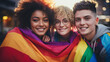 Portrait of Three Friends With A Large Rainbow Flag Behind Them