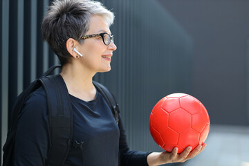 Sticker - Mature woman enjoys outdoor sports, playing with a ball, radiating health and happiness on the court.