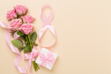 Wall Mural - Composition with pink roses, gift box and eight made of ribbon on color background, top view. Women's day concept