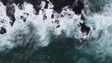 Overhead View Captured By Drone Of Violent Ocean Waves Crashing On The Shore Of A Hawaii Beach On The Island Of Kauai During A Storm. The Whitecap Sea Water Is Exploding On The Rocky Shore. 