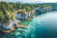 Aerial Panoramic Drone Photograph Of A Rocky Coast Line In The Pacific Ocean With Clear Blue Water And Rocky Cliff With Trees