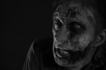 Wall Mural - Scary zombie on dark background, black and white effect. Halloween monster