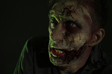 Wall Mural - Scary zombie on dark background. Halloween monster