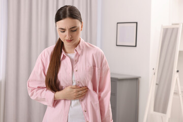 Canvas Print - Young woman suffering from stomach pain at home. Space for text