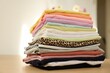 © New Africa - Stack of clean clothes on wooden table