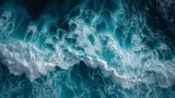 Fototapeta Uliczki - beautiful photo of blue water flowing in waves with white foam in a ocean. taken from up top above perspective. wallpaper background 16:9