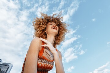 Sticker - Beach Bliss: Smiling Woman with Backpack Dancing for Freedom on a Summer Vacation