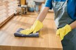 © sorapop - Housewife or maid in modern kitchen wipes dining table surface. Using professional cleaning products for home tidiness. Cleaner at work safety glove hygiene routine. Maid housekeeping concept.